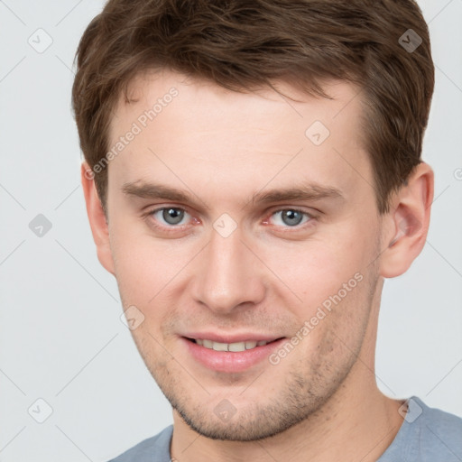 Joyful white young-adult male with short  brown hair and grey eyes