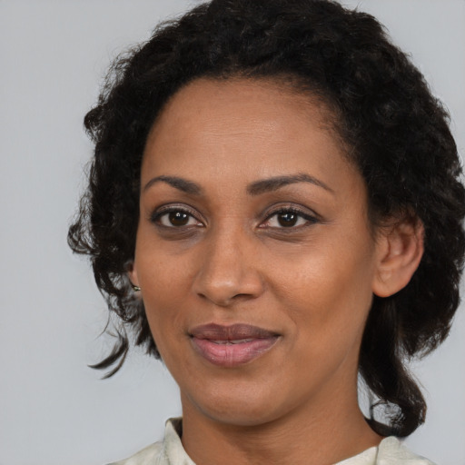 Joyful black young-adult female with medium  brown hair and brown eyes