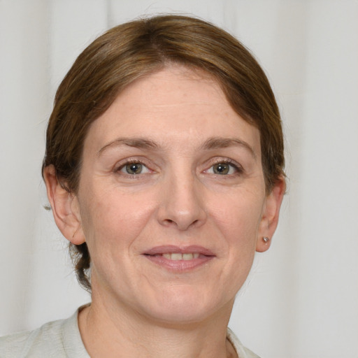 Joyful white adult female with medium  brown hair and grey eyes