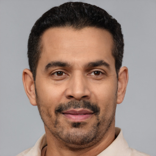 Joyful latino adult male with short  black hair and brown eyes