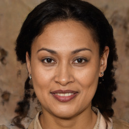 Joyful latino adult female with medium  brown hair and brown eyes