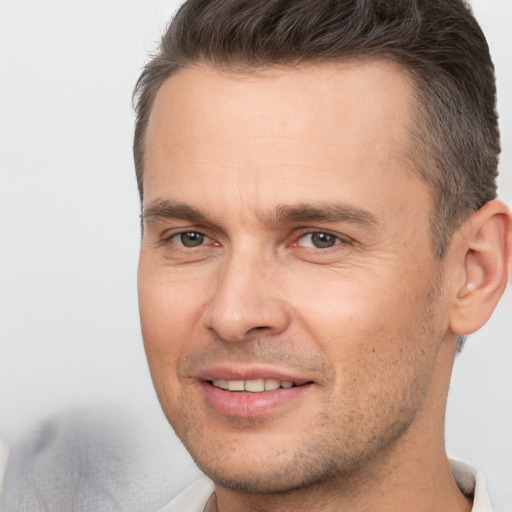 Joyful white adult male with short  brown hair and brown eyes