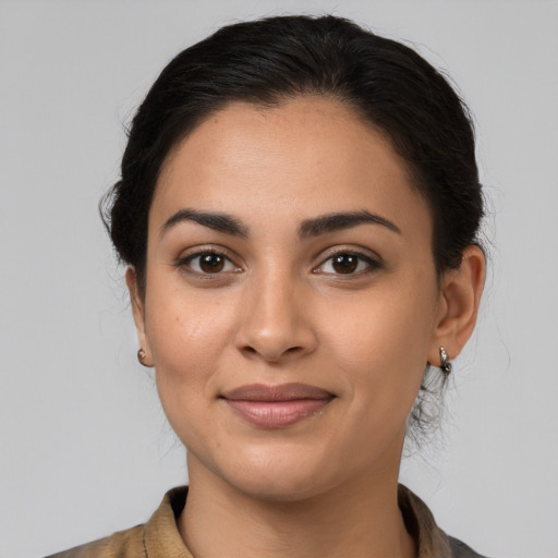 Joyful latino young-adult female with medium  brown hair and brown eyes