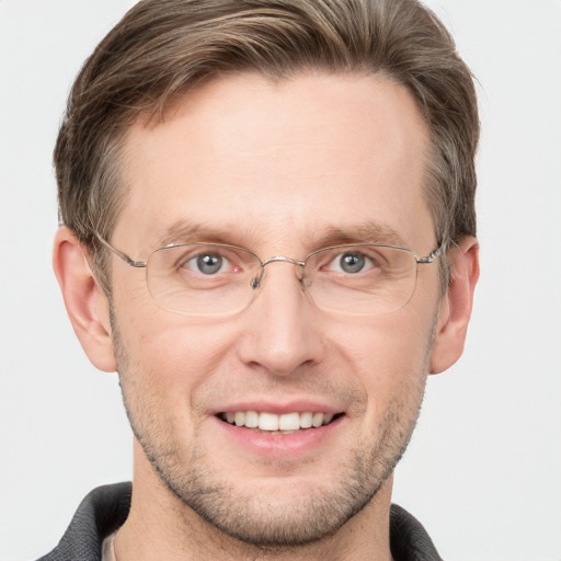 Joyful white adult male with short  brown hair and grey eyes