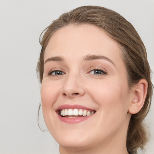 Joyful white young-adult female with medium  brown hair and blue eyes