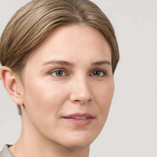 Joyful white young-adult female with short  brown hair and grey eyes