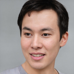 Joyful asian young-adult male with short  brown hair and brown eyes