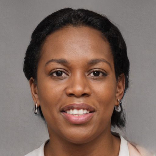 Joyful black young-adult female with short  black hair and brown eyes