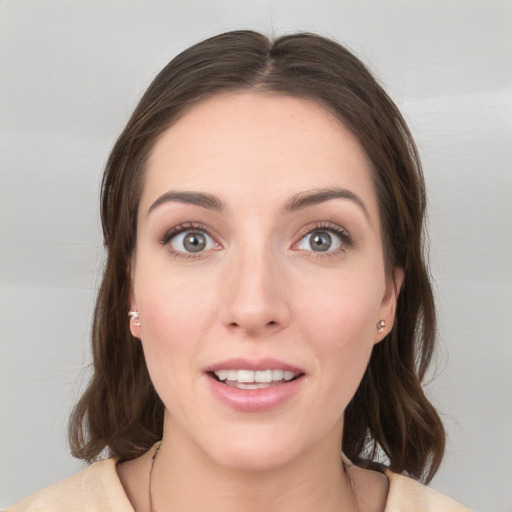 Joyful white young-adult female with medium  brown hair and grey eyes