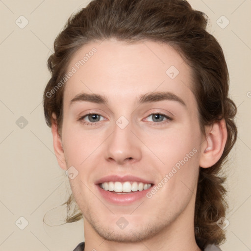 Joyful white young-adult male with medium  brown hair and grey eyes