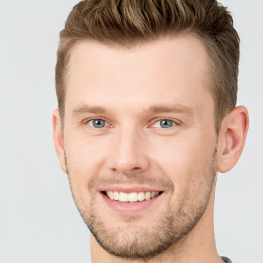 Joyful white young-adult male with short  brown hair and grey eyes