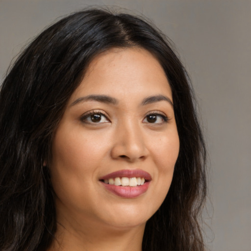 Joyful latino young-adult female with long  brown hair and brown eyes