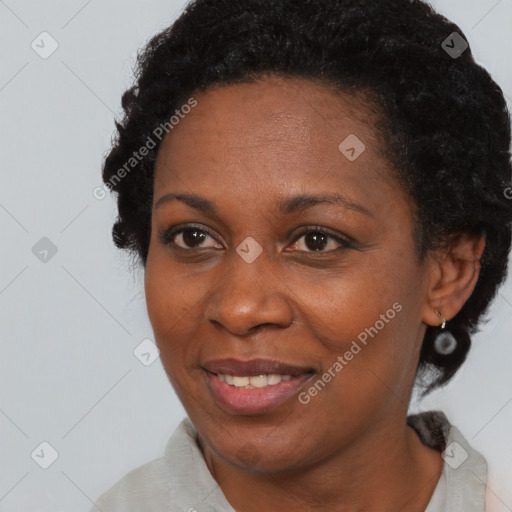 Joyful black adult female with short  black hair and brown eyes