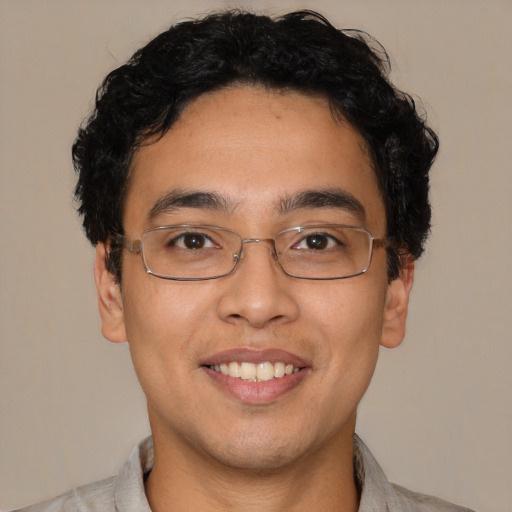 Joyful latino young-adult male with short  brown hair and brown eyes