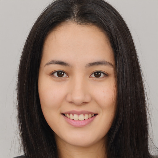 Joyful asian young-adult female with long  brown hair and brown eyes