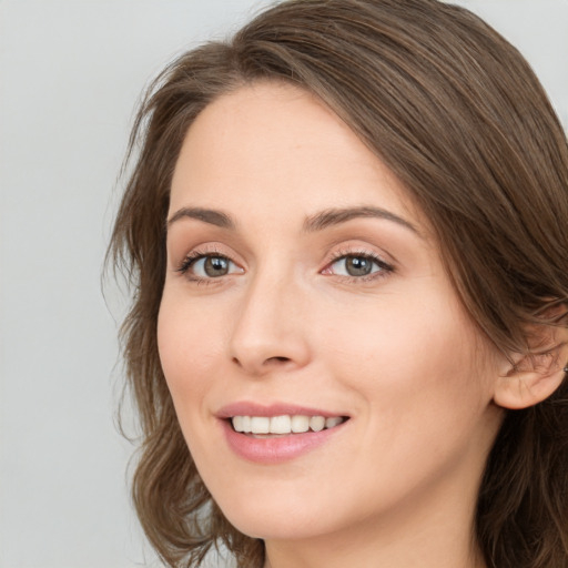 Joyful white young-adult female with long  brown hair and green eyes