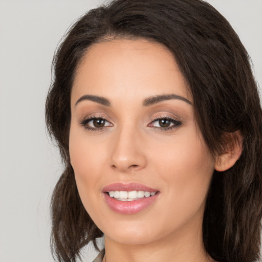 Joyful white young-adult female with long  brown hair and brown eyes