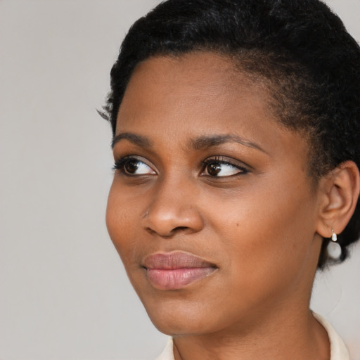Joyful black young-adult female with short  black hair and brown eyes