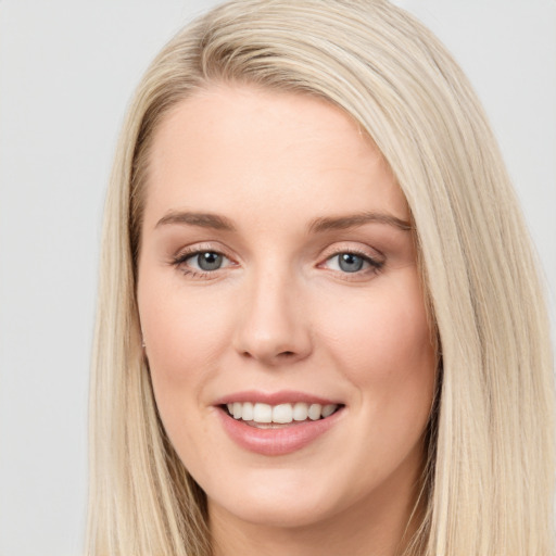 Joyful white young-adult female with long  brown hair and blue eyes