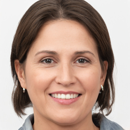 Joyful white adult female with medium  brown hair and grey eyes