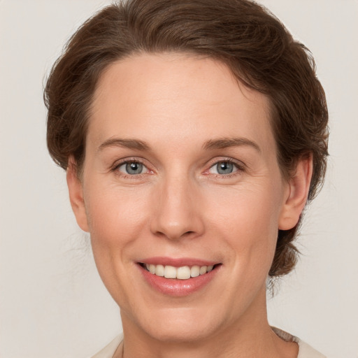 Joyful white adult female with short  brown hair and grey eyes