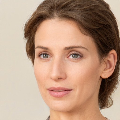 Joyful white young-adult female with medium  brown hair and green eyes