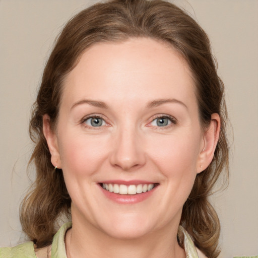 Joyful white young-adult female with medium  brown hair and blue eyes