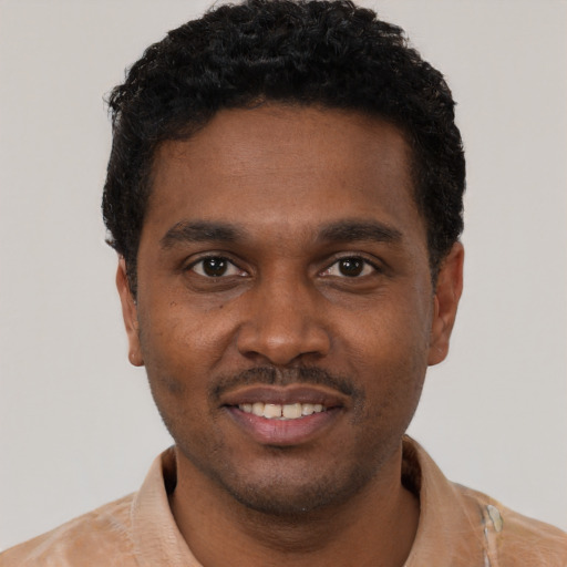 Joyful black young-adult male with short  black hair and brown eyes