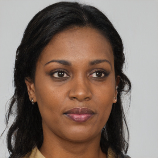 Joyful black young-adult female with long  brown hair and brown eyes