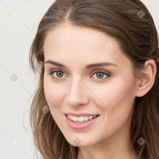 Joyful white young-adult female with long  brown hair and grey eyes