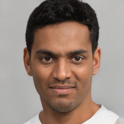 Joyful latino young-adult male with short  black hair and brown eyes