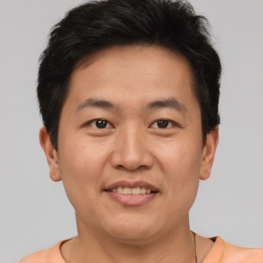 Joyful asian adult male with short  brown hair and brown eyes