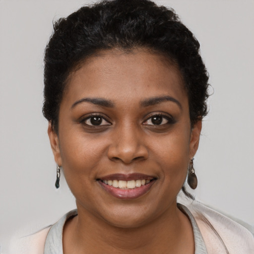 Joyful black young-adult female with short  brown hair and brown eyes