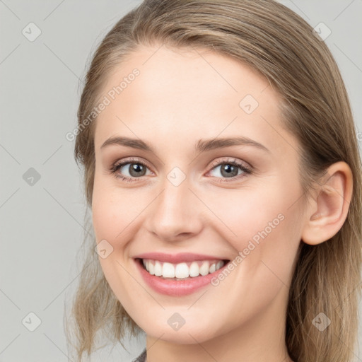 Joyful white young-adult female with long  brown hair and blue eyes