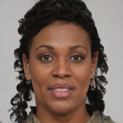Joyful black adult female with long  brown hair and brown eyes