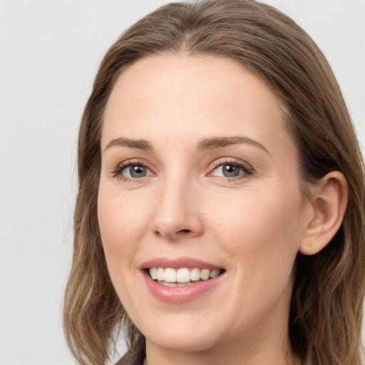 Joyful white young-adult female with long  brown hair and grey eyes