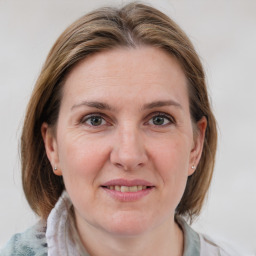 Joyful white adult female with medium  brown hair and grey eyes