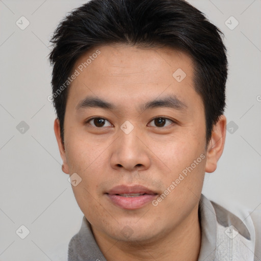 Joyful asian young-adult male with short  black hair and brown eyes