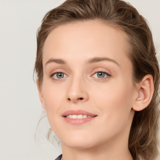 Joyful white young-adult female with long  brown hair and blue eyes