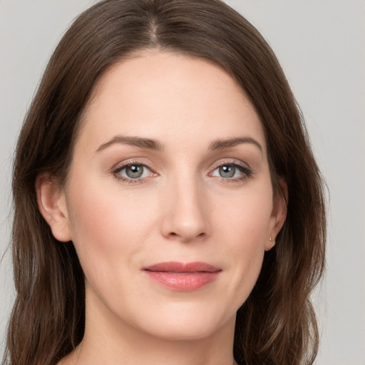 Joyful white young-adult female with long  brown hair and grey eyes