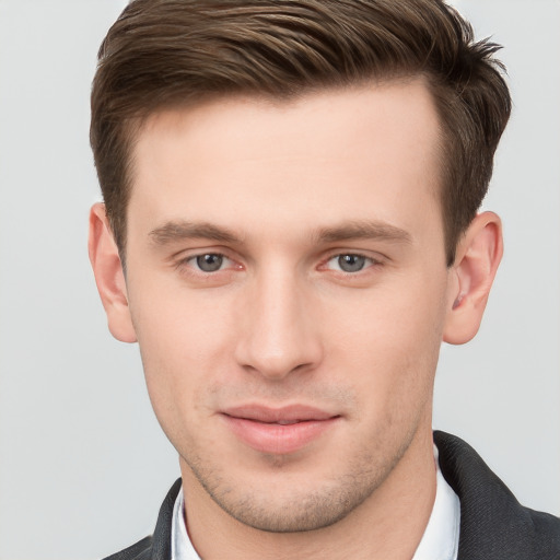 Joyful white young-adult male with short  brown hair and grey eyes