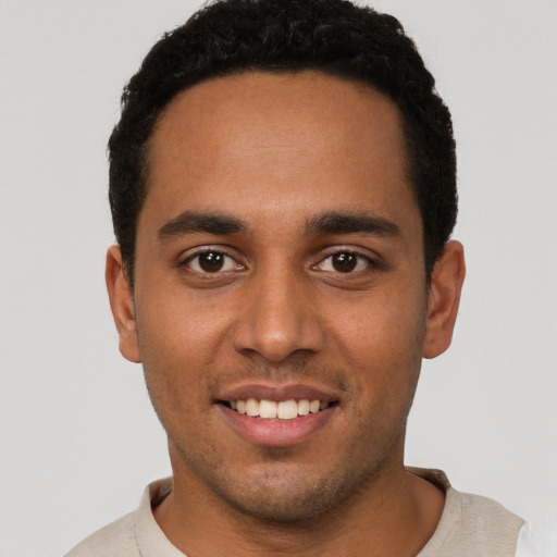 Joyful black young-adult male with short  black hair and brown eyes