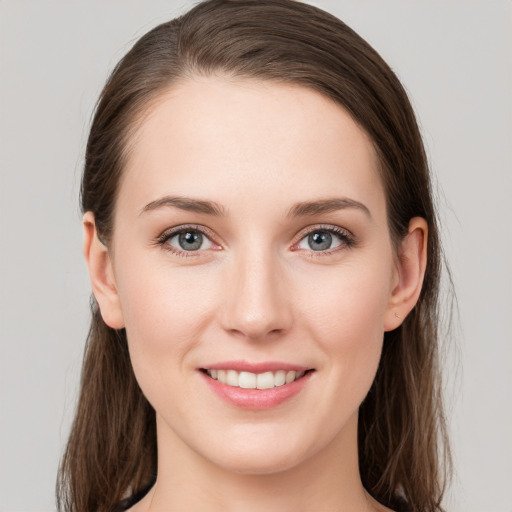 Joyful white young-adult female with long  brown hair and grey eyes