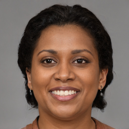 Joyful black young-adult female with medium  brown hair and brown eyes