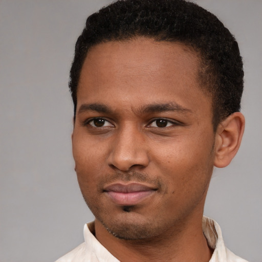 Joyful black young-adult male with short  brown hair and brown eyes