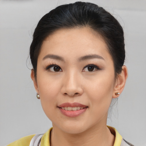 Joyful asian young-adult female with short  brown hair and brown eyes