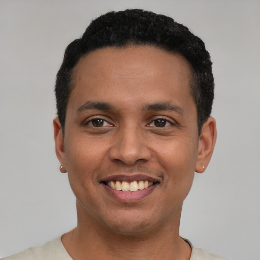 Joyful latino young-adult male with short  black hair and brown eyes