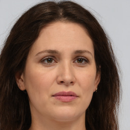 Joyful white adult female with long  brown hair and brown eyes