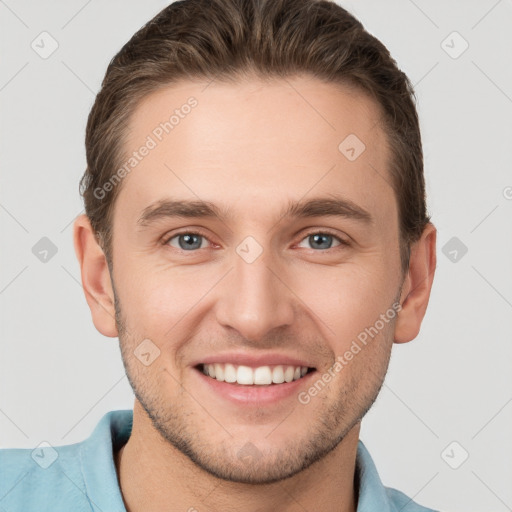 Joyful white young-adult male with short  brown hair and grey eyes