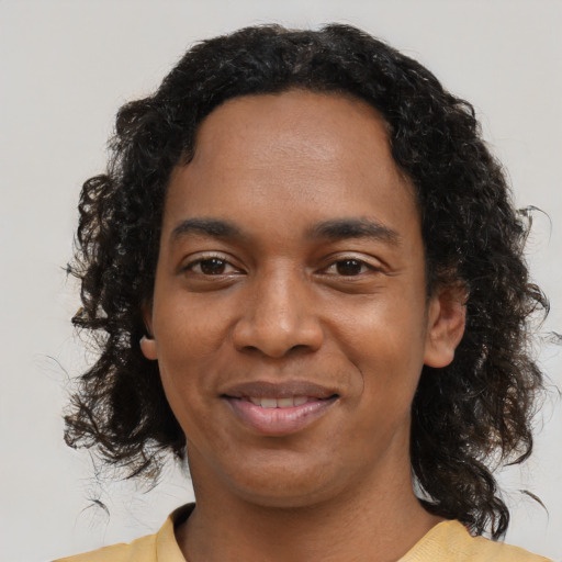 Joyful black young-adult female with medium  black hair and brown eyes